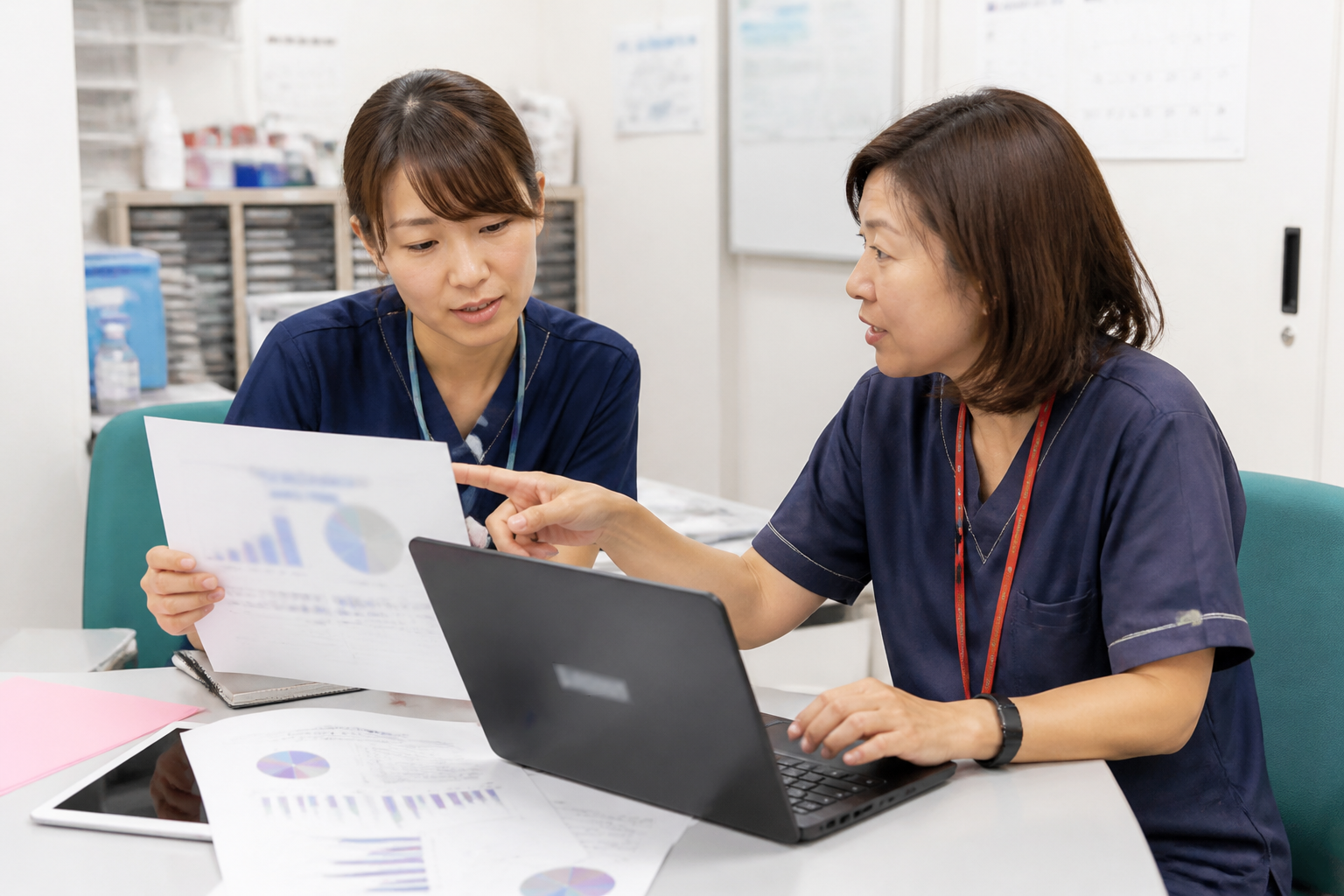訪問看護ステーションで統計資料を確認しながら話し合う看護師