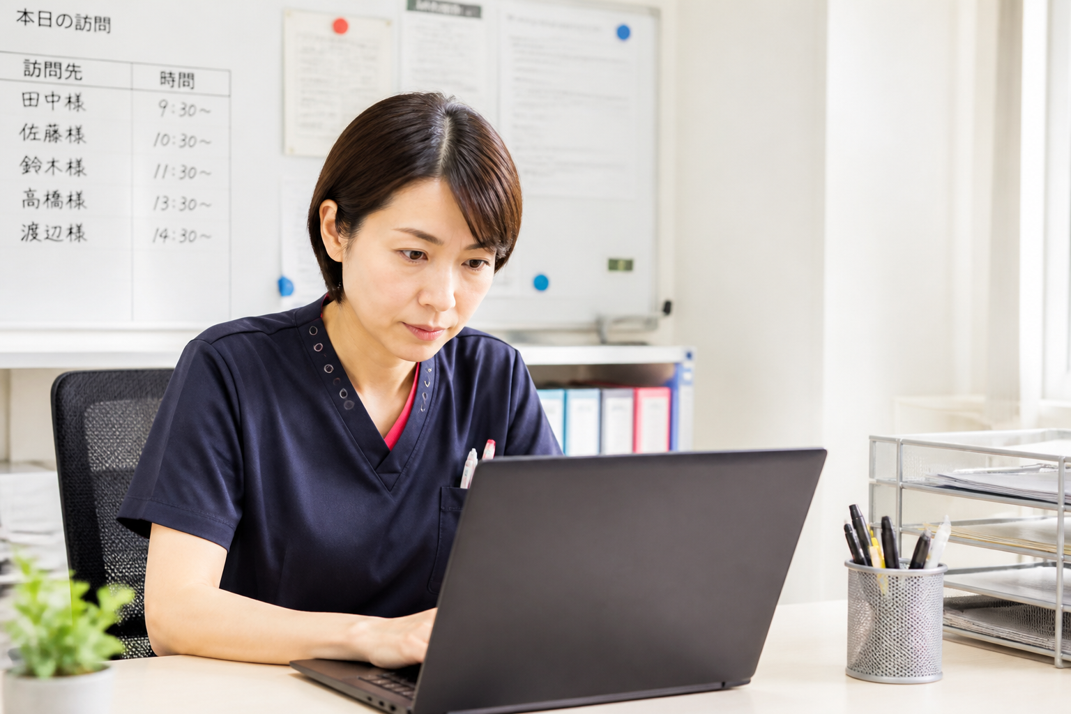 訪問看護師がパソコンで訪問件数とインセンティブの損益データを確認している場面