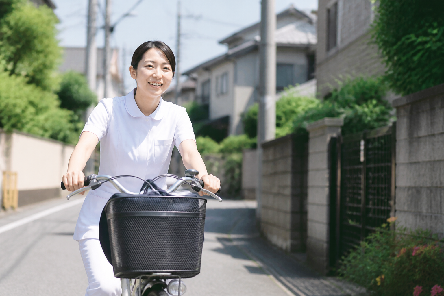 訪問看護師が住宅街を自転車で移動している様子