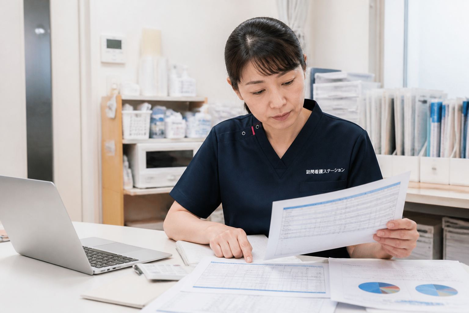 訪問看護ステーションで給与データを確認する看護師