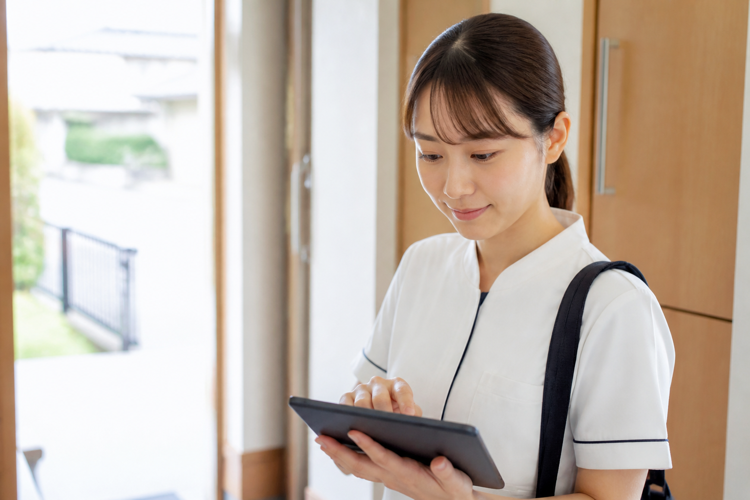 訪問リハビリ後にタブレットでICT記録を入力するスタッフ